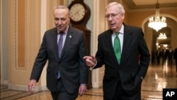 Senate Majority Leader Mitch McConnell, R-Ky., and Senate Minority Leader Chuck Schumer, D-N.Y., left, walk to the chamber after collaborating on an agreement on a two-year, nearly $400 billion budget deal.