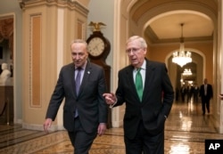 FILE - Senate Republican Majority Leader Mitch McConnell (R) and Senate Democratic Minority Leader Chuck Schumer are seen walking toward the Senate chamber at the capital in Washington, Feb. 7, 2018. McConnell and Schumer are at odds over the timing of the selection process of retiring Justice Anthony Kennedy's replacement.