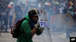 En esta foto de archvio, un manifestante anti gubernamental se protege con un escudo policial durante un enfrentamiento con fuerzas de seguridad el 22 de julio de 2017 en Caracas, Venezuela.
