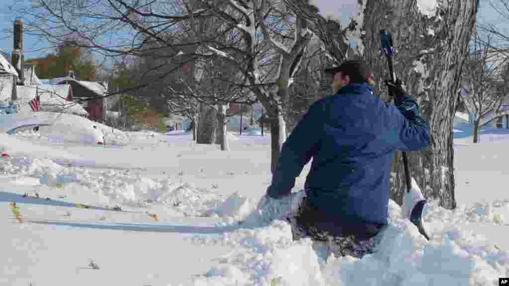 Tom Wilson, 28 ans, de West Seneca, NY, taille haute dans la neige, a profité du congé imposé par la tombée d&rsquo;abondante neige pour essayer de pelleter son chemin, nettoyant le trottoir, vers le bas de Buffalo, NY, le mercredi 19 novembre 2014. Il se dirigeait vers la maison d&#39;un ami, après avoir passé 36 heures à l&#39;entrepôt de boissons de consommation où il travaille.