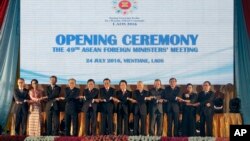 FILE- In this June 24, 2016, file photo, Laotian Prime Minister Thongloun Sisoulith, sixth from left, and Laotian Foreign Minister Saleumxay Kommasith, sixth from right, join their hands with Southeast Asian foreign ministers, from left, an unidentified delegate from Malaysia, Aung San Suu Kyi of Myanmar, Vivian Balakrishnan of Singapore, Don Pramudwinai of Thailand, Pham Binh Minh of Vietnam, Thongloun Sisoulith, Saleumxay Kommasith, Perfecto Yasay Jr. of the Philippines, Brunei's Trade Minister Jock Seng Pehin Lim, Sakhonn Prak of Cambodia, Retno Marsudi of Indonesia and ASEAN Secretary General Le Luong Minh, as they pose for a group photo during the opening ceremony of the 49th Association of Southeast Asian Nations (ASEAN) Foreign Ministers' Meeting in Vientiane, Laos. Despite the Philippines taking on China in a territorial dispute in the South China Sea and winning big, other Southeast Asian nations with similar disputes who attended this week's meetings are apparently backing do