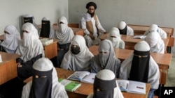 FILE - Afghan girls attend a religious school in Kabul, Afghanistan, on Aug. 11, 2022.