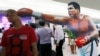 Seorang penggemar Filipina berpose bersama gambar Muhammad Ali di pameran foto dan memorabilia untuk mengenang Muhammad Ali, di Quezon city, Filipina, 10 Juni 2016.