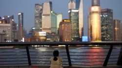 A woman sits on the Bund near Huangpu river as she looks on the financial district of Pudong in Shanghai, China September 27, 2024. REUTERS/Tingshu Wang CHINA-ECONOMY/
