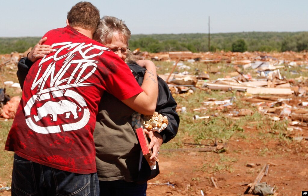 Shelly Hobbie, right, the mother of tornado victim Frank "Skip" Hobbie, is hugged by Cory Brown, left, at the site of what is left of her son's mobile home at the Hideaway Mobile Home Villa in Woodward, Oklahoma April 15, 2012. (AP Photo/Sue Ogrocki)