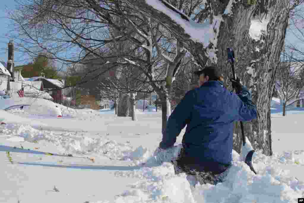 Tom Wilson, 28, of West Seneca, N.Y. , waist high in snow, took advantage of a respite in the snowfall to try to shovel his way down a Buffalo, N.Y., sidewalk,, Nov. 19, 2014.