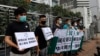 FILE - Members of the Democratic Party hold banners and placards during a protest in front of the Chinese central government's liaison office in Hong Kong, May 22, 2020. 