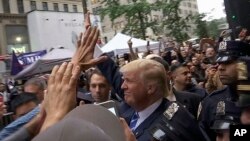 Dalam gambar yang diambil dari video ini, kandidat Presiden AS, Donald Trump, menyambut para pendukungnya di luar gedung Trump Tower miliknya (8/10). New York, New York. (foto: AP Photo/Ezra Kaplan)