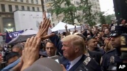 Umukandida Donald Trump aramutsa abanywanyi biwe hanze y'inyubakwa yiwe i New York