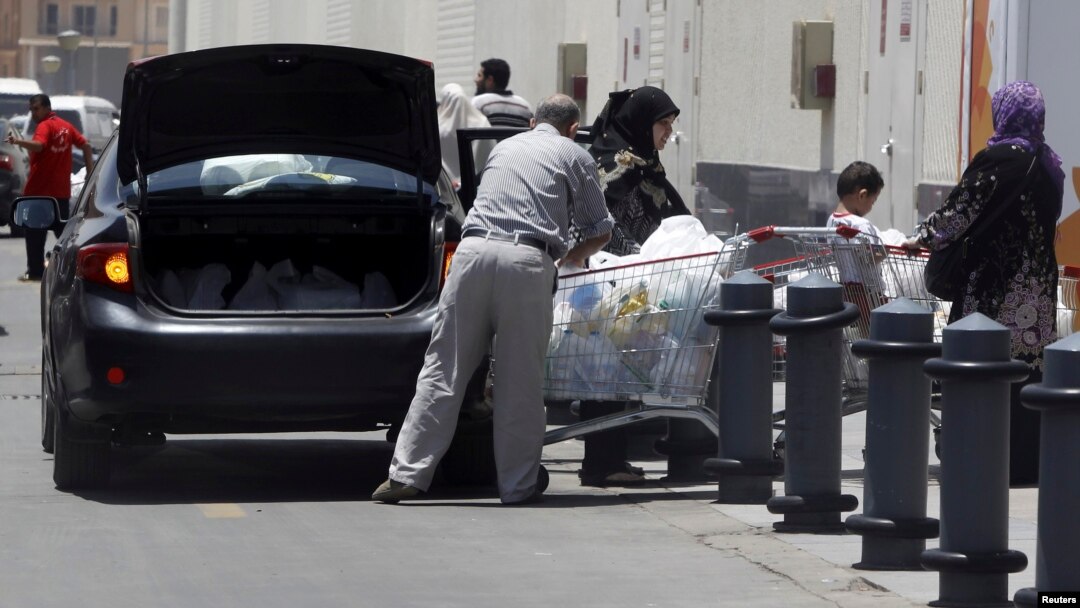A family loads groceries into the trunk of their car ahead of demonstrations against Egyptian President Mohamed Morsi, Cairo, June 25, 2013. 