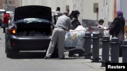 A family loads groceries into the trunk of their car ahead of demonstrations against Egyptian President Mohamed Morsi, Cairo, June 25, 2013. 