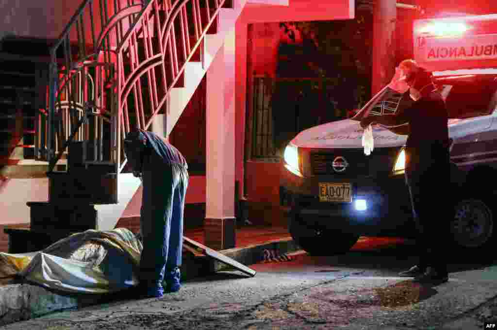 A health worker checks the body of a man on a street in Cucuta, Colombia, July 22, 2020, amid the new coronavirus pandemic.