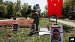 A man tends to a makeshift memorial for the victims of clashes between protesters and riot police at the Gezi Park in Istanbul, Turkey, July 12, 2013.