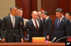 （ 前排坐起）美国总统奥巴马、俄罗斯总统普京和中国主席习近平在北京的亚太经合组织峰会上（2014年11月11日）