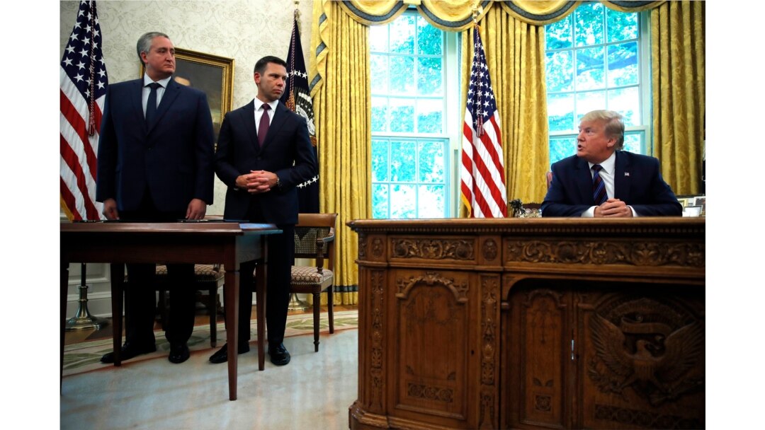 President Donald Trump looks to Acting Secretary of Homeland Security Kevin McAleenan, second from left, and Guatemalan Interior Minister Enrique Degenhart as he speaks to the media in the Oval Office of the White House in Washington, July 26, 2019.