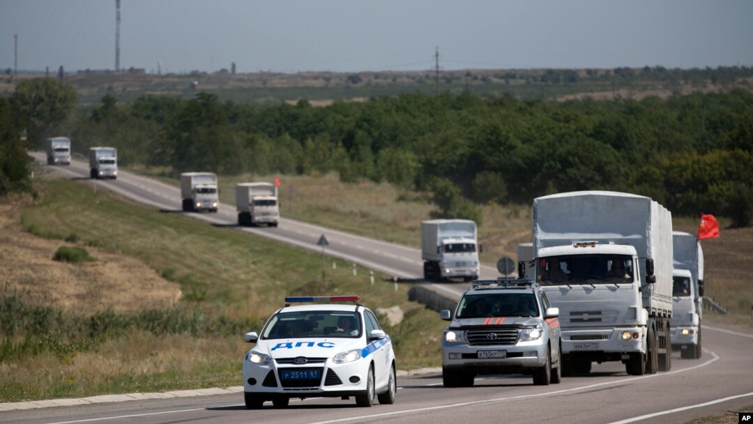Konvoi truk bantuan Rusia membawa bantuan kemanusiaan untuk Ukraina dikawal mobil polisi memasuki perbatasan di kota Rusia, Donetsk, Rostov-on-Don, Rusia, 17 Agustus 2014.