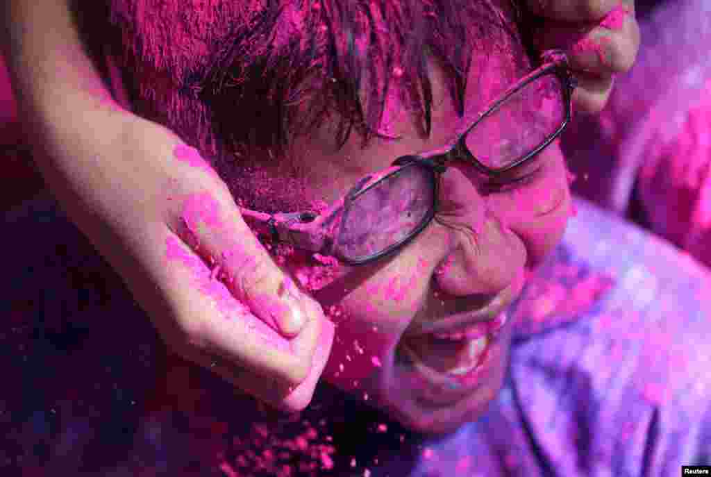 Disabled children cover each other in colored powder during Holi celebrations in Mumbai, India.