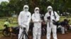 FILE - This picture taken with a self-timer shows AFP journalists in protective gear while reporting on a COVID-19 story at Pondok Ranggon cemetery in Jakarta, May 6, 2020.