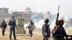 FILE - Nepalese policemen use tear gas to disperse ethnic Madhesi protesters in Gaur, a town about 160 kilometers (100 miles) south of Kathmandu, Dec.20, 2015.