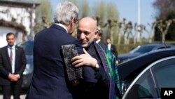 U.S. Secretary of State John Kerry, left, greets Afghan President Hamid Karzai, Brussels, Belgium, April 24, 2013.