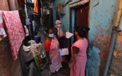 Health workers screen people for tuberculosis and leprosy in Dharavi, one of Asia's biggest slums, in Mumbai, India, Dec. 1, 2020.