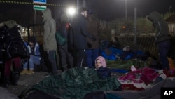 FILE - Migrants gather at a border crossing between Serbia and Hungary in Kelebija, Serbia, on Feb. 6, 2020. Serbian police on Oct. 28, 2023, arrested six people in connection with a deadly shooting between migrant groups near the border.