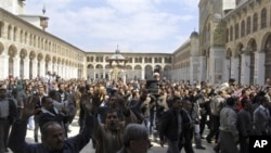 Syrian protesters shout slogans outside the Omayyad Mosque after Friday prayers in Damascus, March 25, 2011