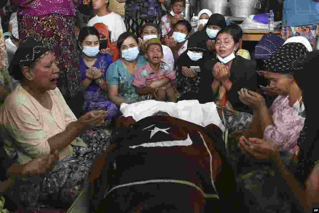 Family and relatives pray next to the body of the Muslim woman who her family said was killed by the army Sunday, during her funeral service in Mandalay, Myanmar.