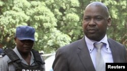 Zimbabwe's Prosecutor General Johannes Tomana (R) arrives escorted by policemen at the Harare Magistrates court, Feb. 2, 2016. 