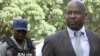 FILE: Zimbabwe's Prosecutor General Johannes Tomana (R) arrives escorted by policemen at the Harare Magistrates court, Feb. 2, 2016. 