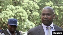 Zimbabwe's Prosecutor General Johannes Tomana (R) arrives escorted by policemen at the Harare Magistrates court, Feb. 2, 2016. 