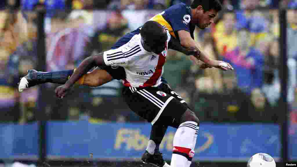 River Plate&#39;s Eder Balanta (front) and Boca Juniors&#39; Lautaro Acosta fight for the ball during their Argentine First Division soccer match in Buenos Aires May 5, 2013.