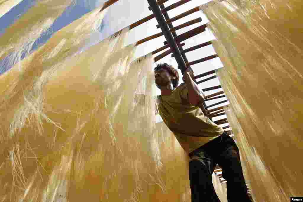 A worker dries vermicelli, a specialty eaten during the Muslim holy month of Ramadan, at a factory in the northern Indian city of Allahabad.