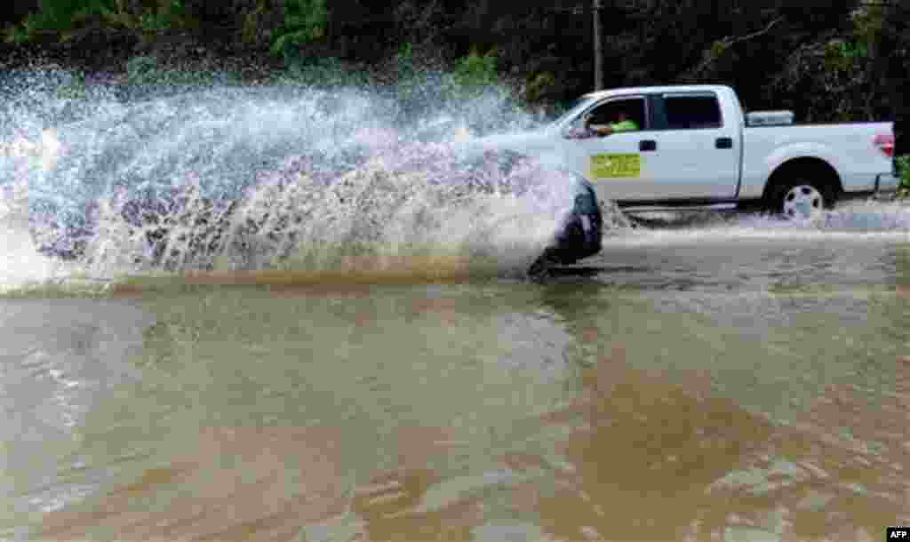 Motorists drive through a flooded street in Leonardtown, Md., after Hurricane Irene, Sunday, Aug. 28, 2011. (AP Photo/Steve Ruark)