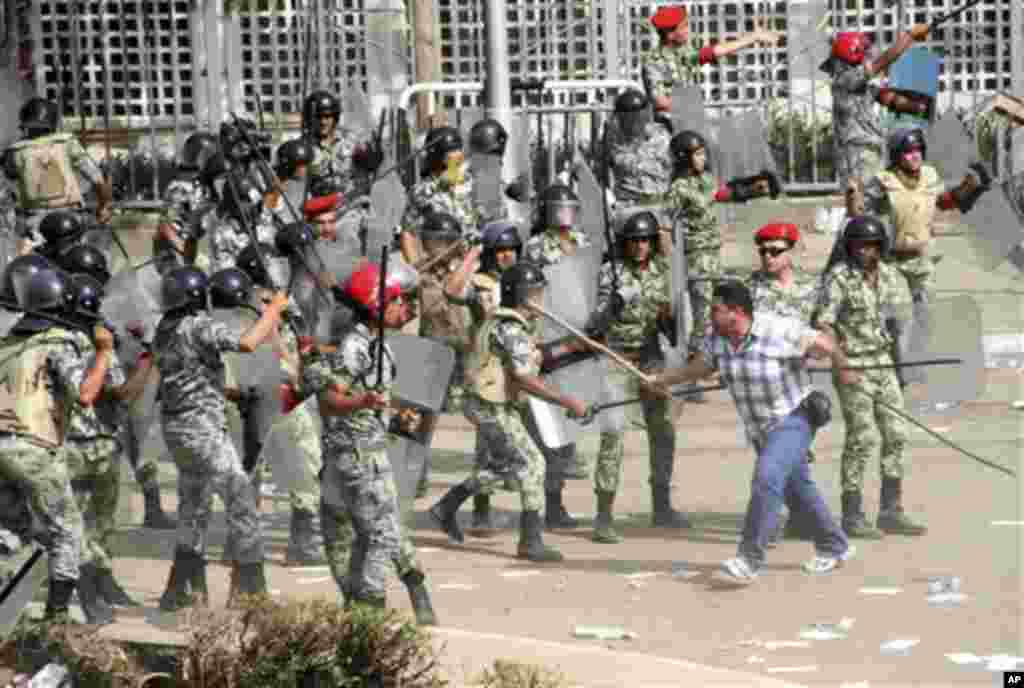 A protester, right, waves a stick at Egyptian soldiers during clashes outside the Ministry of Defense in Cairo, Egypt, Friday, May 4, 2012. Egyptian armed forces and protesters clashed in Cairo on Friday, with troops firing water cannons and tear gas at d