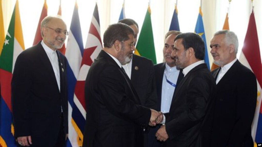 Presiden Iran Mahmoud Ahmadinejad menyambut President Mesir Mohammed Morsi dalam pembukaan KTT Gerakan Non Blok di Teheran (30/8). 