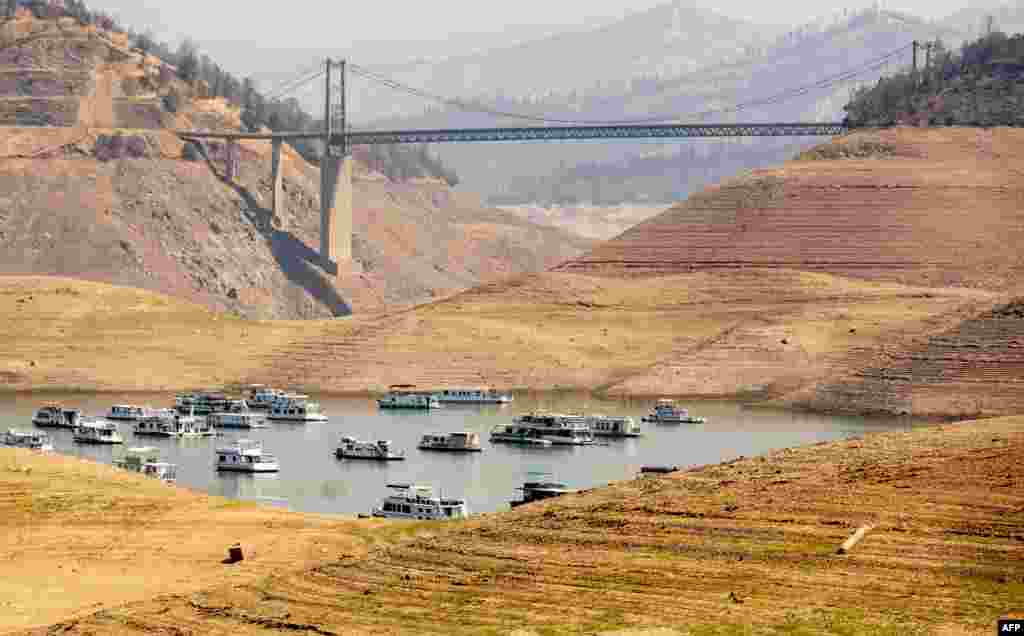 Houseboats sit in a narrow section of water in a depleted Lake Oroville in Oroville, California, Sept. 5, 2021.