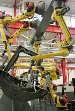 Arms from a robotic welder simulate welds on a piece of metal in Euclid, Ohio. Today's welding technicians operate robots that can do welds quicker than humans and with more precision.