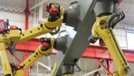 Arms from a robotic welder simulate welds on a piece of metal in Euclid, Ohio. Today's welding technicians operate robots that can do welds quicker than humans and with more precision.