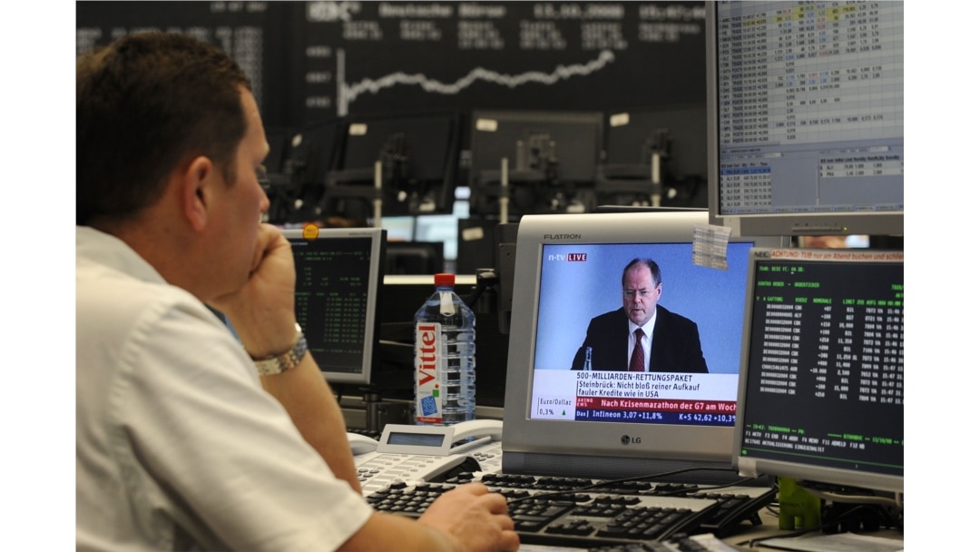 FILE - A share trader watches German Finance Minister Peer Steinbrueck's on an incresing impact of the global financial crisis, on television at the Frankfurt stock exchange, Oct.13, 2008.