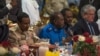 Militia commander Mohamed Hamdan Hemeti Dagolo (left, in khaki uniform) eats an Iftar meal with U.S. Charge D'Affaires Steven Koutsis (far right, in suit), in Khartoum, Sudan, May 18, 2019.