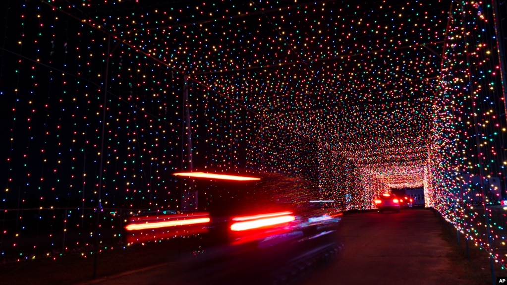 Passenger vehicles move through a tunnel of holiday lights at a display set up at the Cumberland Fair Grounds, Tuesday, Dec. 14, 2021, in Cumberland, Maine. (AP Photo/Robert F. Bukaty)