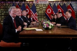 John Bolton, left, and others attend an extended bilateral meeting between North Korea's leader Kim Jong Un and U.S. President Donald Trump, in Hanoi, Vietnam, Feb. 28, 2019.