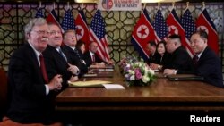 John Bolton, left, and others attend an extended bilateral meeting between North Korea's leader Kim Jong Un and U.S. President Donald Trump, in Hanoi, Vietnam Feb. 28, 2019. 