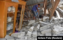 A villager walks through the ruins of a collapsed house during a search for the equipment of Malaysian tourists who died during the earthquake at the Sembalun Selong village in Lombok Timur, Indonesia, July 29, 2018.