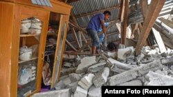 Un aldeano camina a través de las ruinas de una casa derrumbada durante una búsqueda del equipo de turistas malasios que murieron durante el terremoto en la aldea Sembalun Selong en Lombok Timur, Indonesia, el 29 de julio de 2018.