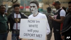 In this Wednesday, Feb. 7, 2018 photo, African migrants gather during a protest in front of Rwanda embassy in Herzeliya, Israel. 