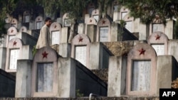 一位中国民众行走在1979年中越战争阵亡将士墓园中。（2007年2月22日）