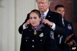 President Donald Trump presents the Medal of Honor to Nicole Battaglia of the Alexandria, Virginia Police Department during a ceremony in the East Room of the White House in Washington, July 27, 2017.