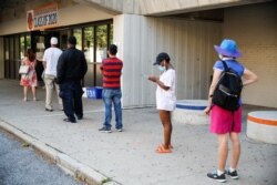 Voters wait in line to cast their ballots in New York's primary election at a polling station inside Yonkers Middle/High School, in Yonkers, New York, June 23, 2020.